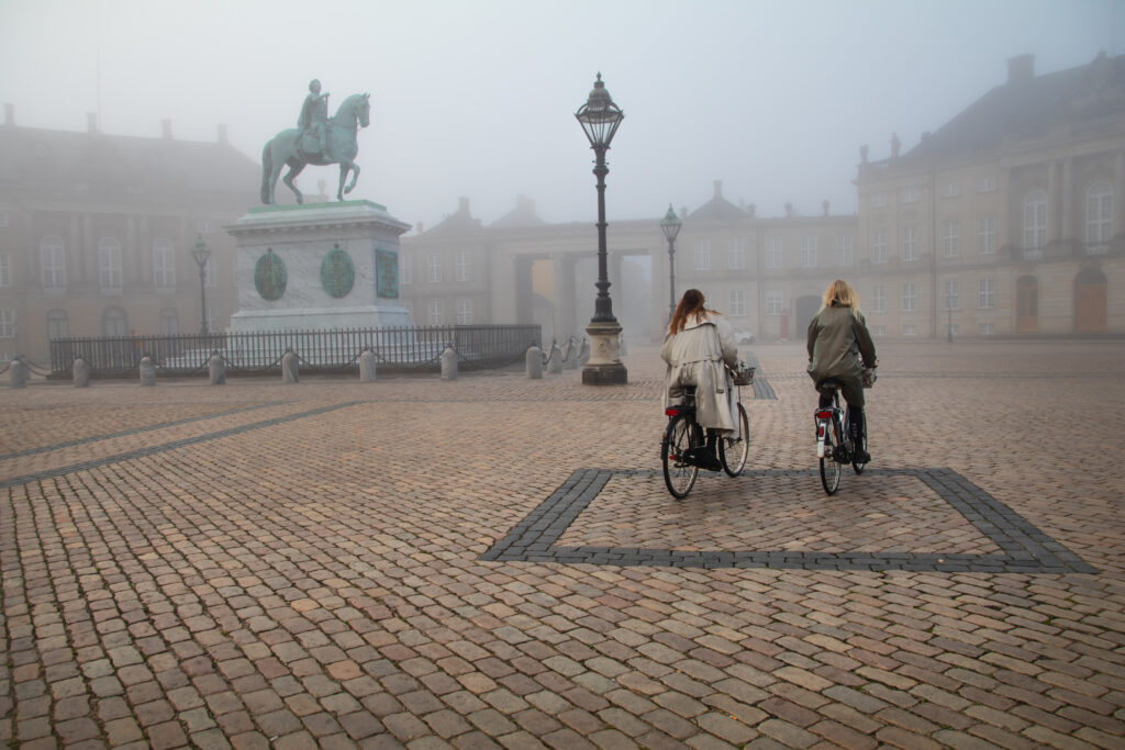 Photo of two girls cyclists on Amelieborg square in Copenhagen